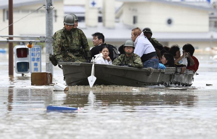 Người dân Nhật Bản được đưa ra khỏi khu vực ngập lụt ở Kurashiki. Ảnh: Reuters.