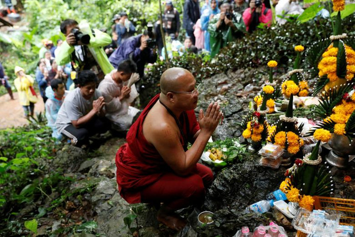 Một nhà sư cầu nguyện bên ngoài hang động Tham Luang ngày 27/6. Ảnh: Reuters.