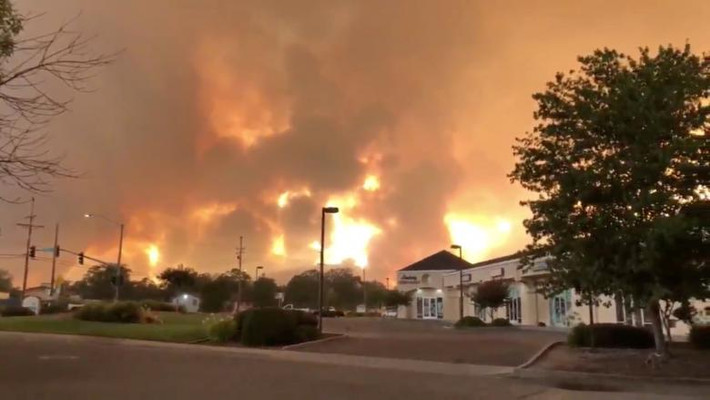 Khói lửa bốc lên ngùn ngụt phía sau một tòa nhà ở Redding, bang California.