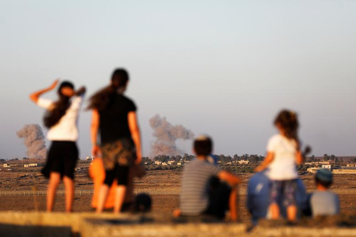 Các em nhỏ Israel nhìn sang phía bên kia biên giới Syria.