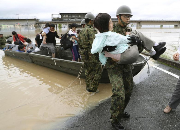 Các binh sĩ Nhật Bản đưa người dân đến nơi an toàn ở Kurashiki. Ảnh: Reuters.