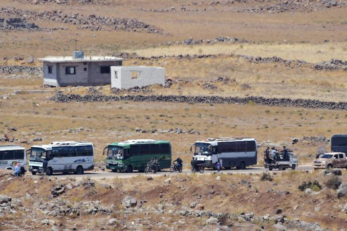 Đoàn xe buýt di chuyển trên đường ở khu vực biên giới phía Syria ngày 20/7.