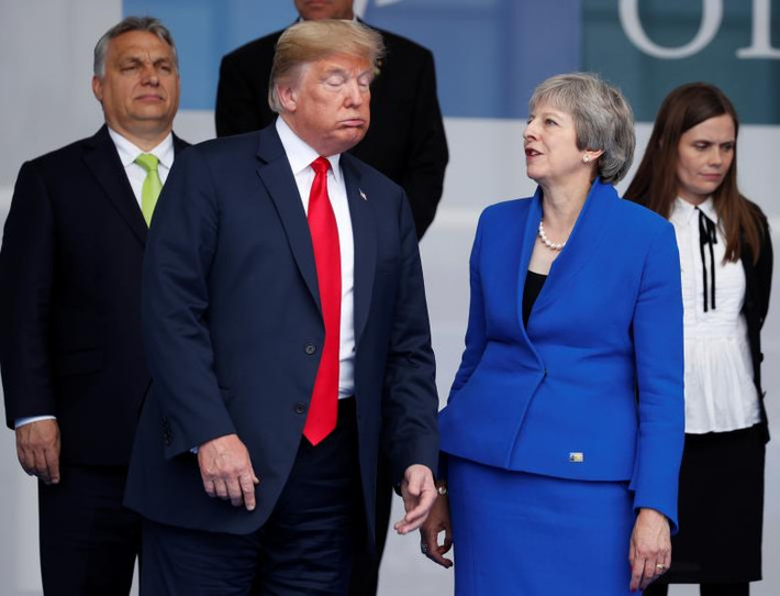 Biểu cảm của Tổng thống Trump và Thủ tướng Anh Theresa May khi đứng chụp ảnh lưu niệm chuẩn bị khai mạc hội nghị. Theo Daily Mail, Tổng thống Trump đã nói rằng nước Anh đang trong thời kỳ "hỗn loạn" vì Brexit và ngỏ ý gặp ông Boris Johnson, người vừa từ chức Ngoại trưởng Anh, khi ông tới thăm nước này. Ảnh: Reuters.