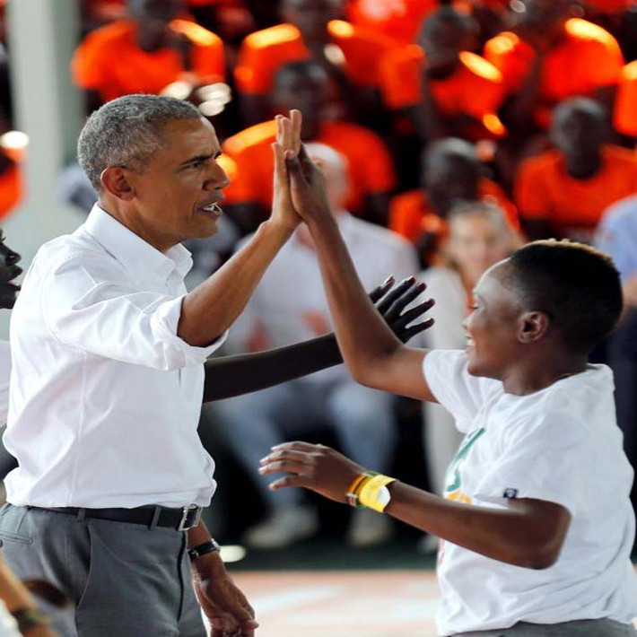 Ông Obama đập tay với một cầu thủ trên sân bóng rổ trong trung tâm.