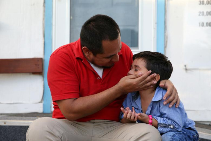 Walter Armando Jimenez Melendez, đến từ El Salvador, âu yếm cậu con trai 4 tuổi Jeremy tại cơ sở lưu trú La Posada Providencia ở San Benito, Texas, ngày 10/7. Họ đã không được gặp nhau từ cuối tháng 5/2018. Ảnh: Reuters.
