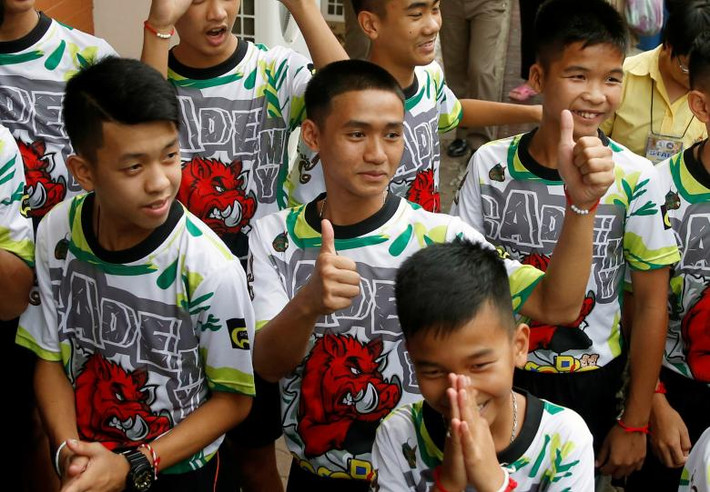 Các cầu thủ và huấn luyện viên của đội bóng nhí Thái Lan cười tươi khi tới tham dự buổi họp báo.