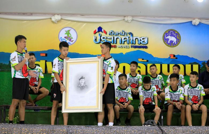 Hai cầu thủ nhí cầm bức vẽ chân dung thợ lặn Saman Kunan tại buổi họp báo. Các em sẽ đến thăm gia đình của thợ lặn Kunan và gửi tặng gia đình bức vẽ chân dung này.