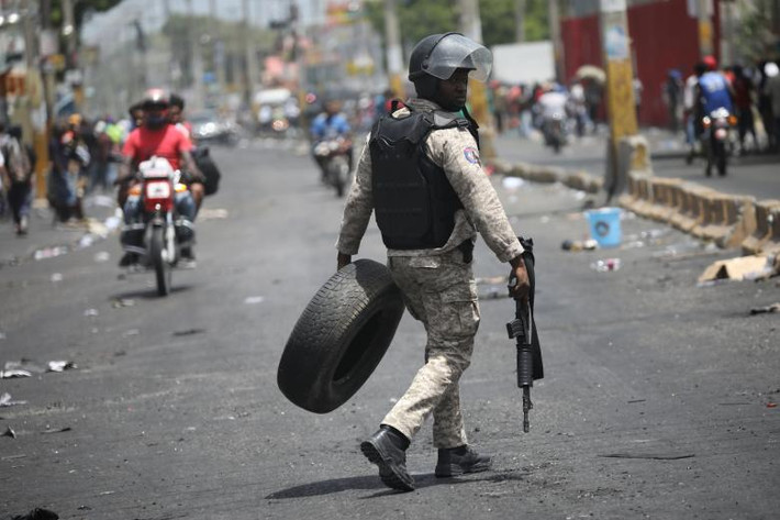 Một cảnh sát Haiti mang theo vũ khí trên đường phố Port-au-Prince.
