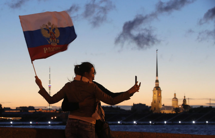 Các du khách chụp ảnh “tự sướng” tại bờ sông Neva vào lúc sau 0h sáng ở thành phố Saint Petersburg, Nga.