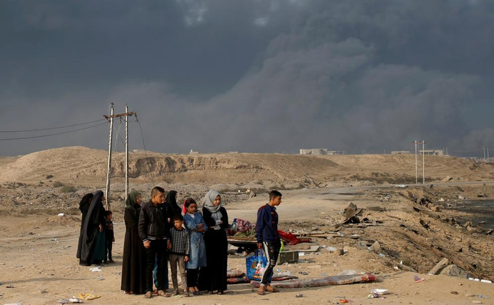 Người dân đứng tại một chốt kiểm soát ở ngoại ô Qayyara, phía nam Mosul, hôm 27/10.