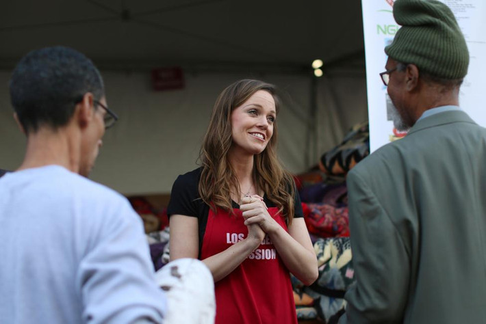 Diễn viên Rachel Boston trò chuyện với mọi người trong lúc phân phát chăn miễn phí sau khi phục vụ bữa ăn cho người dân sống tại quận Skid Row, Los Angeles, hôm 23/11. Ảnh Reuters