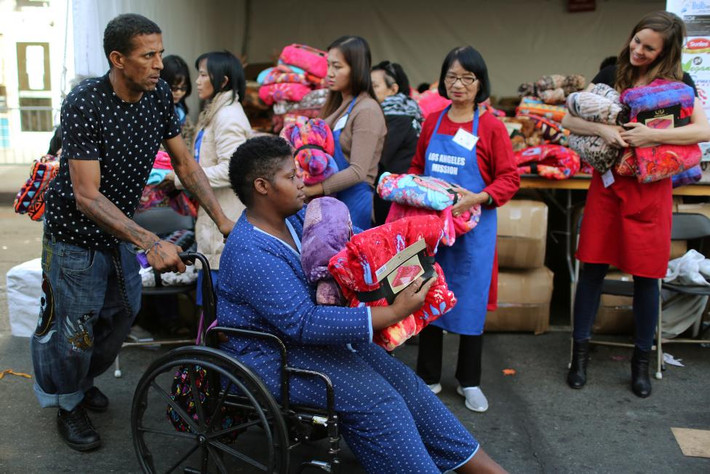 Người dân ở quận Skid Row nhận chăn được phân phát miễn phí hôm 23/11. Ảnh Reuters