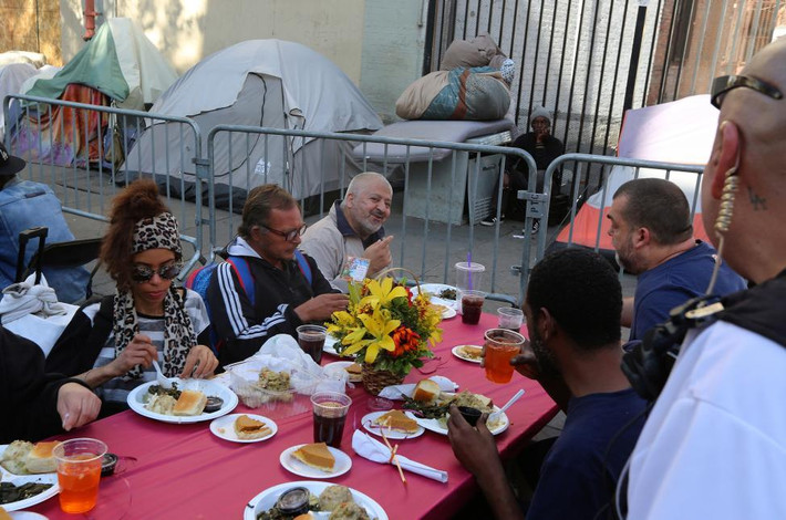 Người dân Mỹ thưởng thức bữa ăn dịp Lễ Tạ ơn tại quận Skid Row, Los Angeles, hôm 23/11. Ảnh Reuters