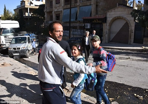 Một người đàn ông Syria sơ tán các em học sinh ra khỏi trường. Ảnh: Getty Images.