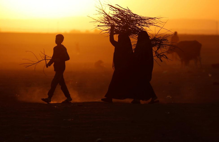 Người dân Iraq sơ tán mang củi tại ranh giới lãnh thổ của người Kurd gần thị trấn Bashiqa, Iraq, ngày 18/11.