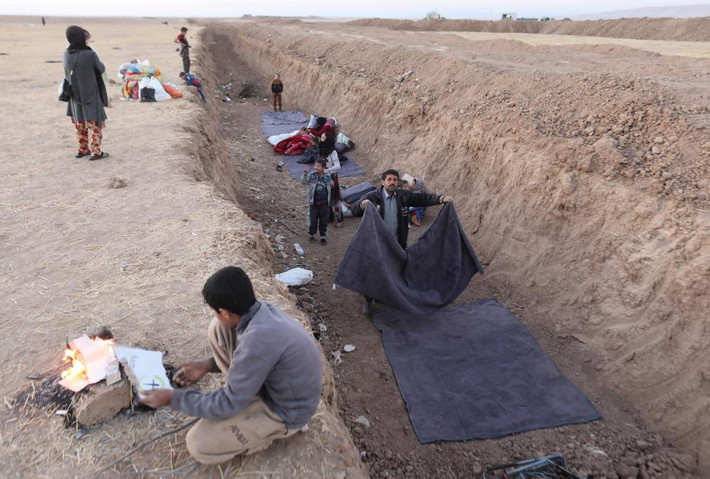 Người dân Iraq sơ tán trong các cuộc giao tranh ở trong và ngoại ô Mosul phải ngủ trong một chiến hào gần Bashiqa, Iraq.