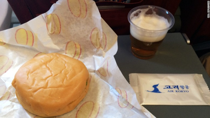 Bữa ăn trên chuyến bay có bánh hamburger và bia Triều Tiên. (Nguồn ảnh: CNN)