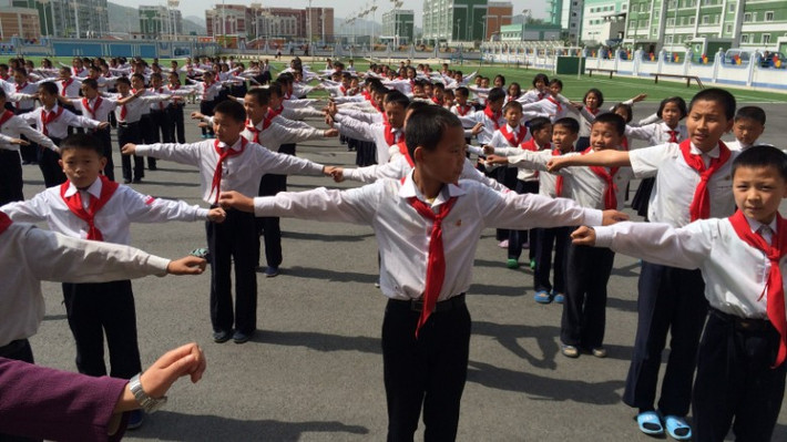 Các em học sinh trung học ở Triều Tiên tập thể dục ngoài trời.