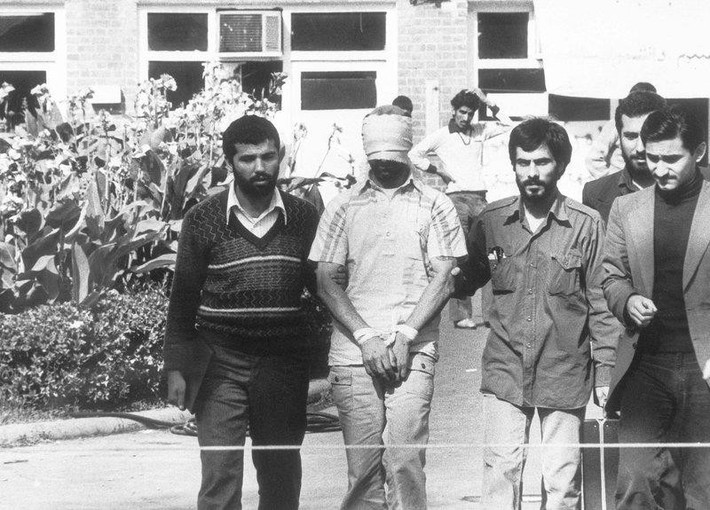 Một con tin Mỹ được các sinh viên Iran dẫn ra trước đám đông. Một số con tin được thả tự do sau đó, nhưng phải mất hơn một năm để những con tin còn lại được thả. Hai tháng trước vụ việc, Iran đóng cửa văn phòng AP tại Tehran và tống khứ các nhà báo Mỹ về nước. Ảnh: AP.