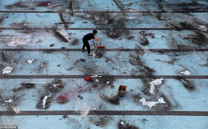 Hoạt động dọn dẹp "bãi chiến trường" tại trường Đại học Bách khoa Hong Kong. Ảnh: Reuters.