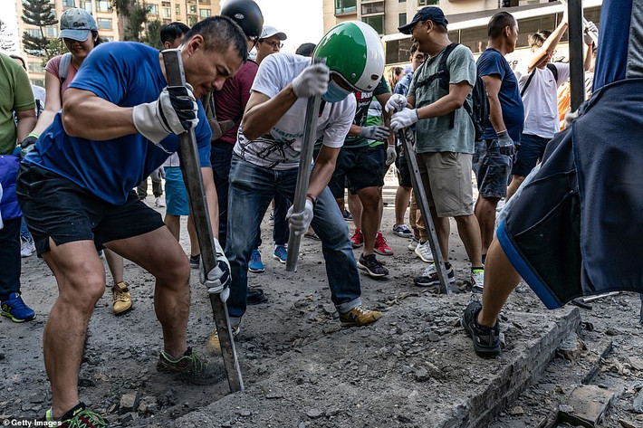 Lực lượng lính cứu hỏa, cảnh sát Hong Kong và người dân địa phương cũng tham gia công tác dọn dẹp đường phố Hong Kong trong ngày 16/11 vừa qua. Ngoài ra còn có một số người biểu tình. Ảnh: Getty.