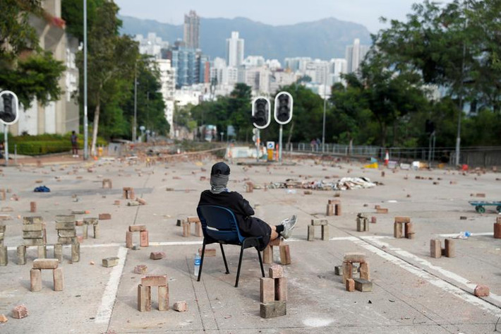 Một người biểu tình ngồi giữa bãi gạch bên ngoài một trường đại học ở Kowloon Tong ngày 12/11.