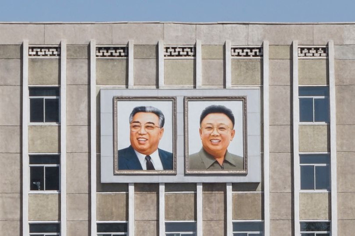 Bức chân dung nhà sáng lập Triều Tiên Kim Il-sung và cố Chủ tịch Kim Jong-il được treo trên tòa nhà gần công viên giải trí Taesongsan. Ảnh: Mirror.