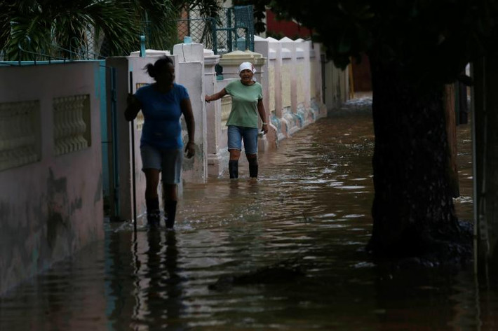 Người phụ nữ lội qua con phố ngập lụt ở thủ đô La Habana, Cuba, ngày 9/9. Ảnh: Reuters.
