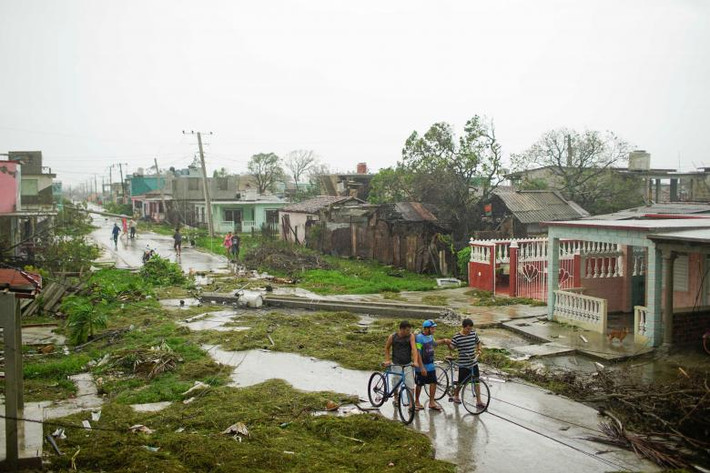 Người dân đi qua con đường ngổn ngang sau bão ở Caibarien, Cuba. Ảnh: Reuters.