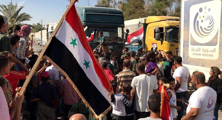 Cư dân Deir Ezzor chào đón đoàn xe cứu trợ chở thực phẩm và thuốc men. Ảnh: Sputnik.