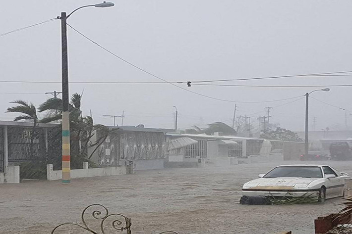 Chiếc ô tô "mắc kẹt" trên con đường ngập nước ở thành phố San Juan. Ảnh: Reuters.