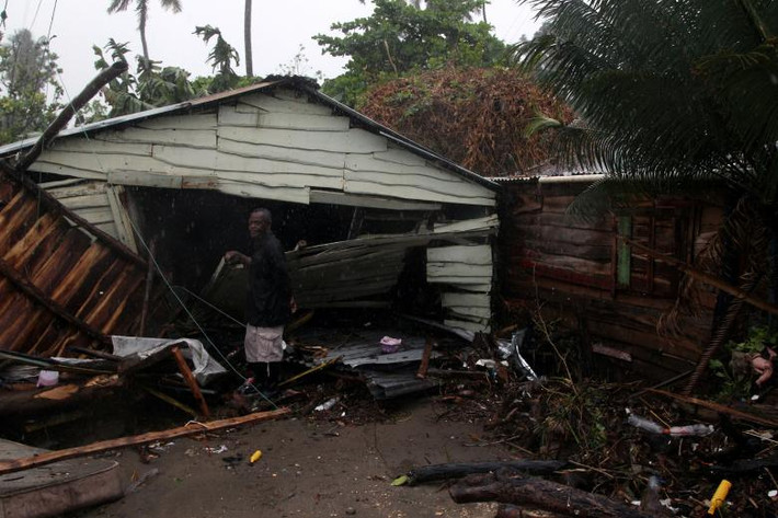 Người đàn ông đứng bên ngoài ngôi nhà của mình bị hư hại sau bão ở Nagua. Ảnh: Reuters.