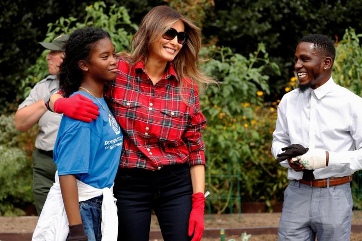 Đệ nhất phu nhân Melania Trump mặc quần bò, áo sọc caro và đeo găng tay đỏ khi tham gia hoạt động này. Ảnh: Reuters.