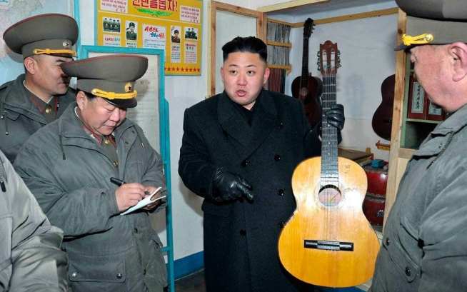 Nhà lãnh đạo Kim Jong-un cầm cây đàn ghi-ta trong chuyến thăm một đơn vị quân đội. Ảnh: Telegraph.