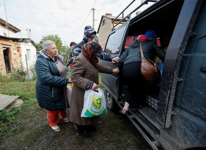 Người dân địa phương lên ô tô sơ tán đến nơi an toàn. Ảnh: Reuters.