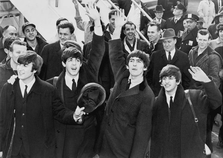 Các thành viên của ban nhạc The Beatles (Anh) vẫy chào người hâm mộ khi họ tới sân bay Kennedy ở thành phố New York năm 1964. Ảnh: ATI.