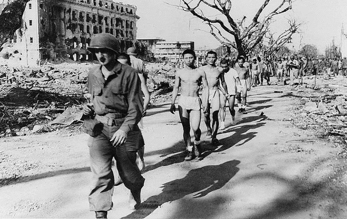 Một binh sĩ Mỹ áp giải những tù nhân chiến tranh Nhật Bản ở Phililppines năm 1943. Ảnh: ATI.