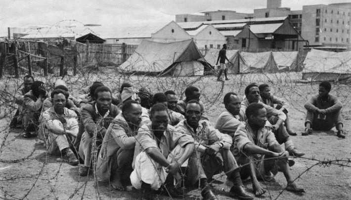 Những đối tượng tình nghi là chiến binh Mau Mau ngồi trong một trại giam ở Nairobi, Kenya, năm 1952. Ảnh: ATI.