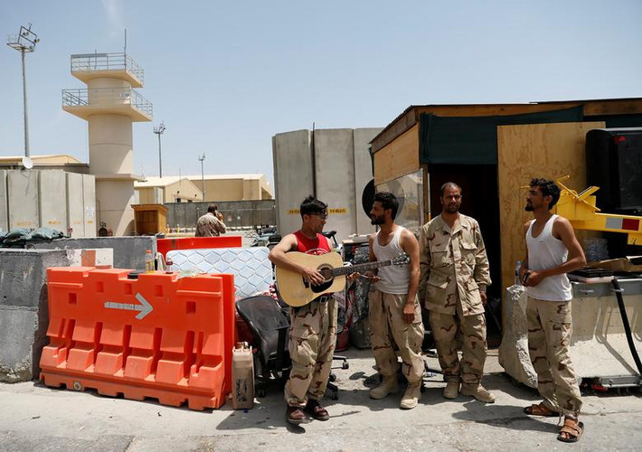 Một binh sĩ Afghanistan chơi đàn guitar trong căn cứ không quân Bagram ngày 5/7. Chiếc đàn guitar được binh sĩ Mỹ để lại.