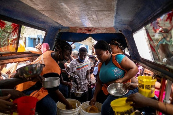 Bức ảnh chụp tình nguyện viên phân phát đồ ăn cho những người dân sơ tán ở thủ đô Haiti.
