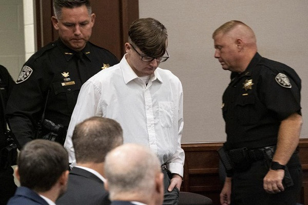 Theo AP, ngày 27/7, thẩm phán ở hạt Cherokee, bang Georgia, đã tuyên Robert Aaron Long 4 án tù chung thân không ân xá, cộng thêm 35 năm tù. Được biết, Long đã ký một thỏa thuận nhận tội giết 4 người với thẩm phán ở hạt Cherokee để tránh bị kết án tử hình. Ảnh: Robert Aaron Long (áo trắng) xuất hiện trong phiên tòa ở Cherokee ngày 27/7. Ảnh: AP.