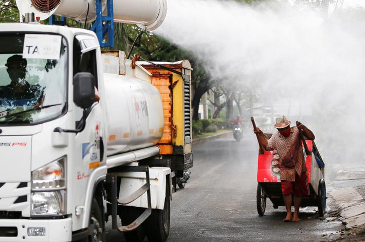 Các thành viên của Hội Chữ thập đỏ Indonesia phun khử khuẩn xung quanh khu Daan Mogot, Jakarta, ngày 30/6.