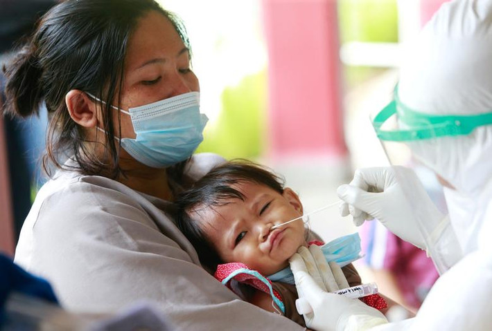 Bé Fawziah, 1 tuổi, được nhân viên y tế lấy mẫu xét nghiệm COVID-19 tại một ngôi trường ở Jakarta, ngày 2/7.