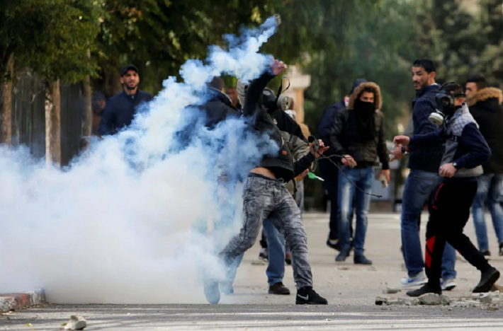 Một người biểu tình Palestine ném lựu đạn hơi cay về phía binh sĩ Israel ở thành phố Bethlehem hôm 7/12. Ảnh: Reuters.