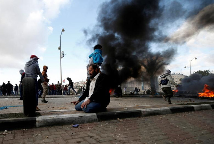 Một người biểu tình Palestine cầu nguyện trong cuộc đụng độ với binh sĩ Israel gần khu định cư Do Thái Beit El gần thành phố Ramallah. Ảnh: Reuters.