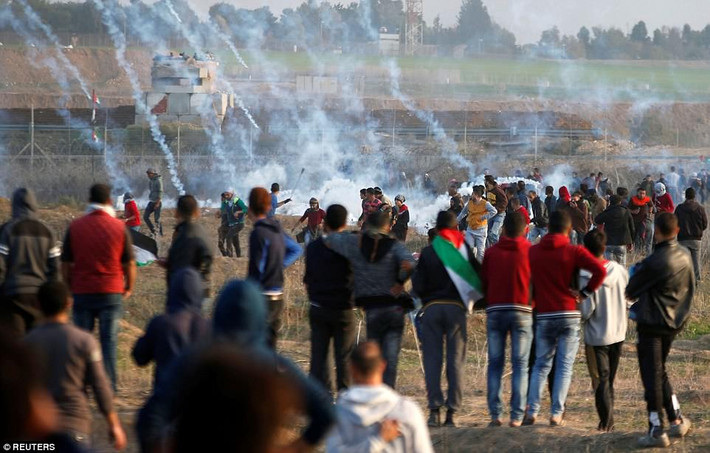 Binh sĩ Israel ném lựa đạn hơi cay về phía đám đông người biểu tình Palestine. Ảnh: Reuters.