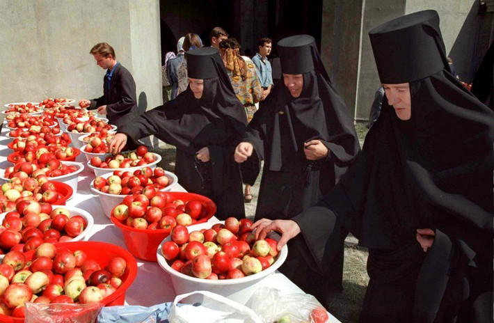 Những nữ tu chọn táo đã được "tắm" nước thánh ở thủ đô Moscow vào tháng 8/1996. Ảnh: Reuters.