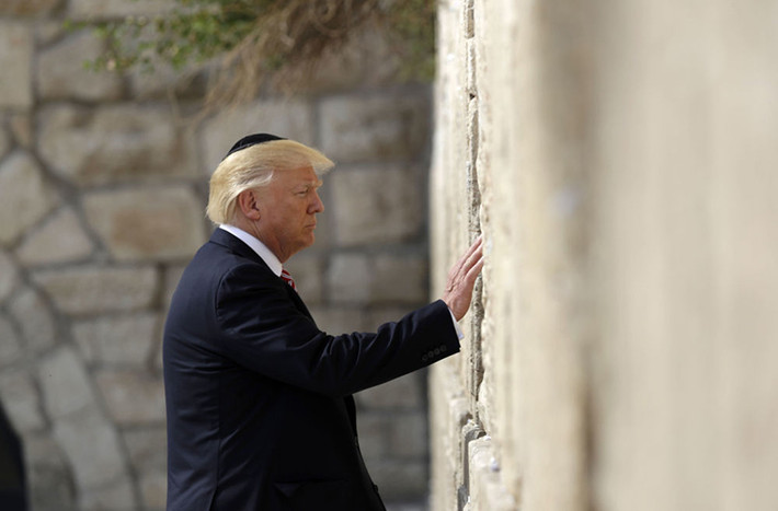 Tuy nhiên, tuyên bố của ông Trump đã đi ngược lại chính sách của Washington trong suốt hàng chục năm qua, đe dọa thổi bùng làn sóng bạo lực tại Trung Đông cũng như làm xáo trộn cuộc sống đang yên bình của người dân ở Jerusalem. Ảnh: Tổng thống Trump đặt tay lên Bức tường phía Tây ở Thành phố cổ Jerusalem ngày 22/5/2017 trong chuyến thăm Israel. Ảnh: Sputnik.