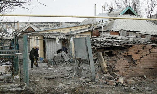 Theo Reuters, xung đột ở miền Đông Ukraine đã leo thang tới mức cao nhất trong những tháng qua, các cuộc đấu pháo của hai bên cũng phá hủy nhiều nhà cửa của dân thường ở vùng chiến sự. Ảnh: Một người phụ nữ Ukraine dọn dẹp đống đổ nát gần ngôi nhà bị hư hại của mình tại thị trấn Yasynuvata do lực lượng ly khai kiểm soát ở miền đông Ukraine ngày 21/12/2017. Ảnh: Reuters.