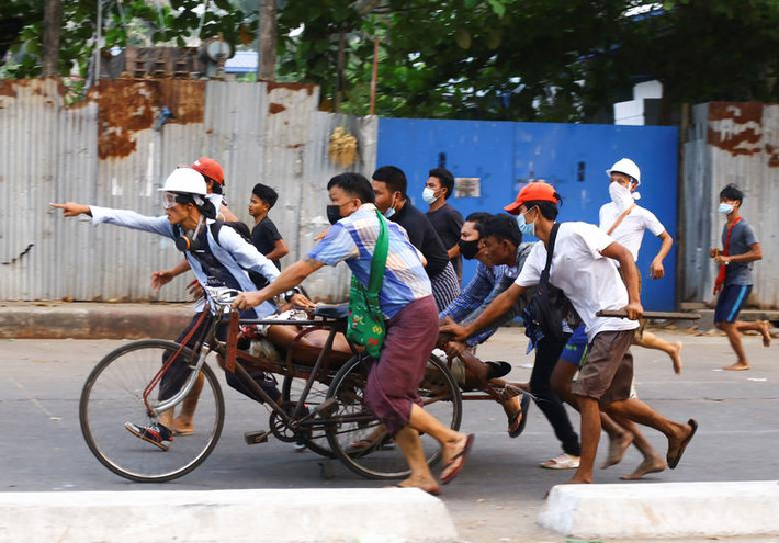 "Họ lục soát mọi tòa nhà trên đường Kyun Taw, phá ổ khóa các căn nhà ở lầu dưới nếu chúng bị khóa", một cư dân địa phương cho biết. Bà cũng nghe nói hàng chục người bị bắt. Ảnh: Một người biểu tình bị thương ở Yangon hôm 14/3.